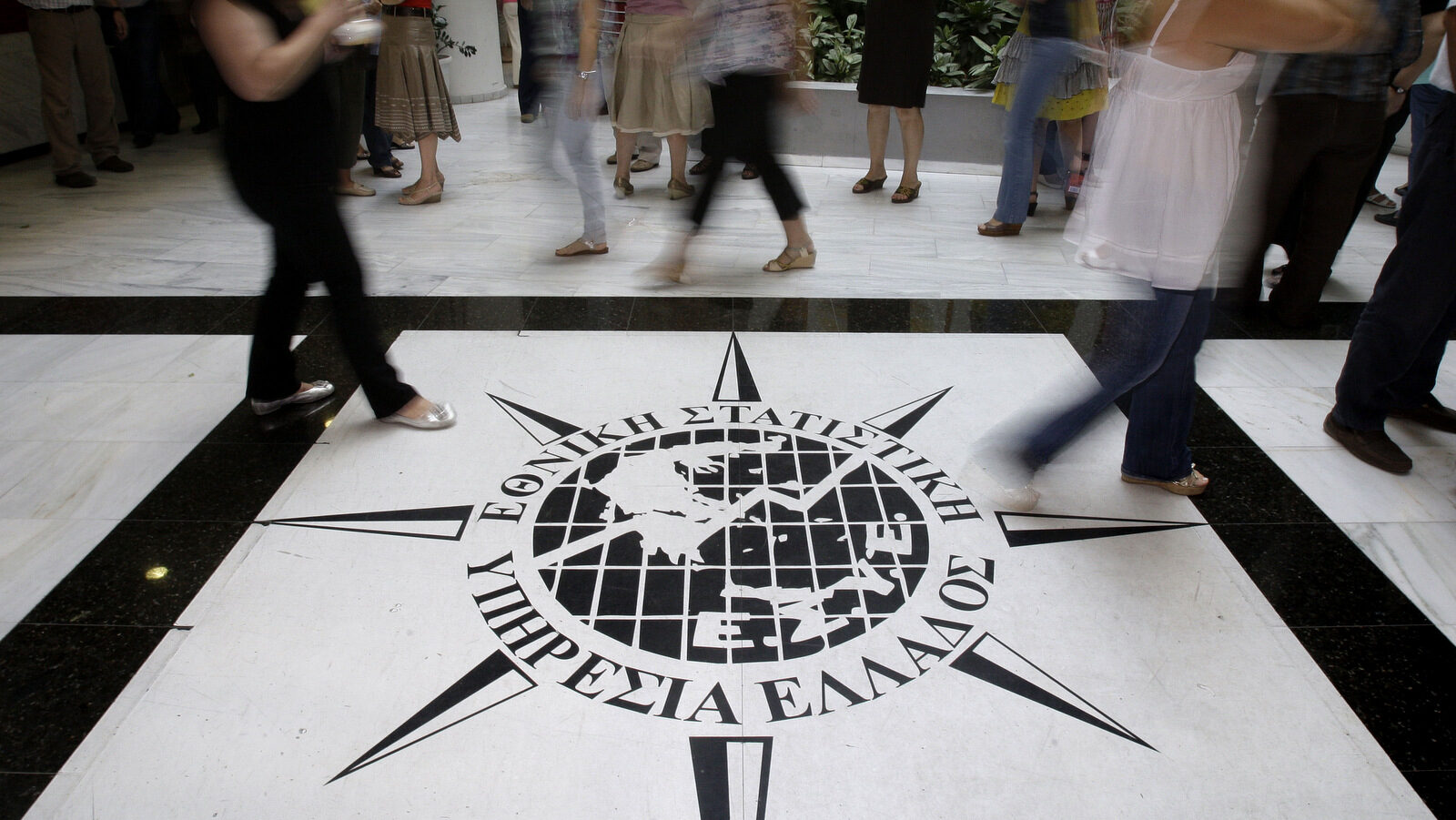 Greece's Statistics agency employees walk past the logo of the agency in Piraeus, near Athens. Serious errors in Greek deficit data, revealed last year, helped trigger the European government debt crisis rattled world markets and confidence in the euro. (AP/Petros Giannakouris)