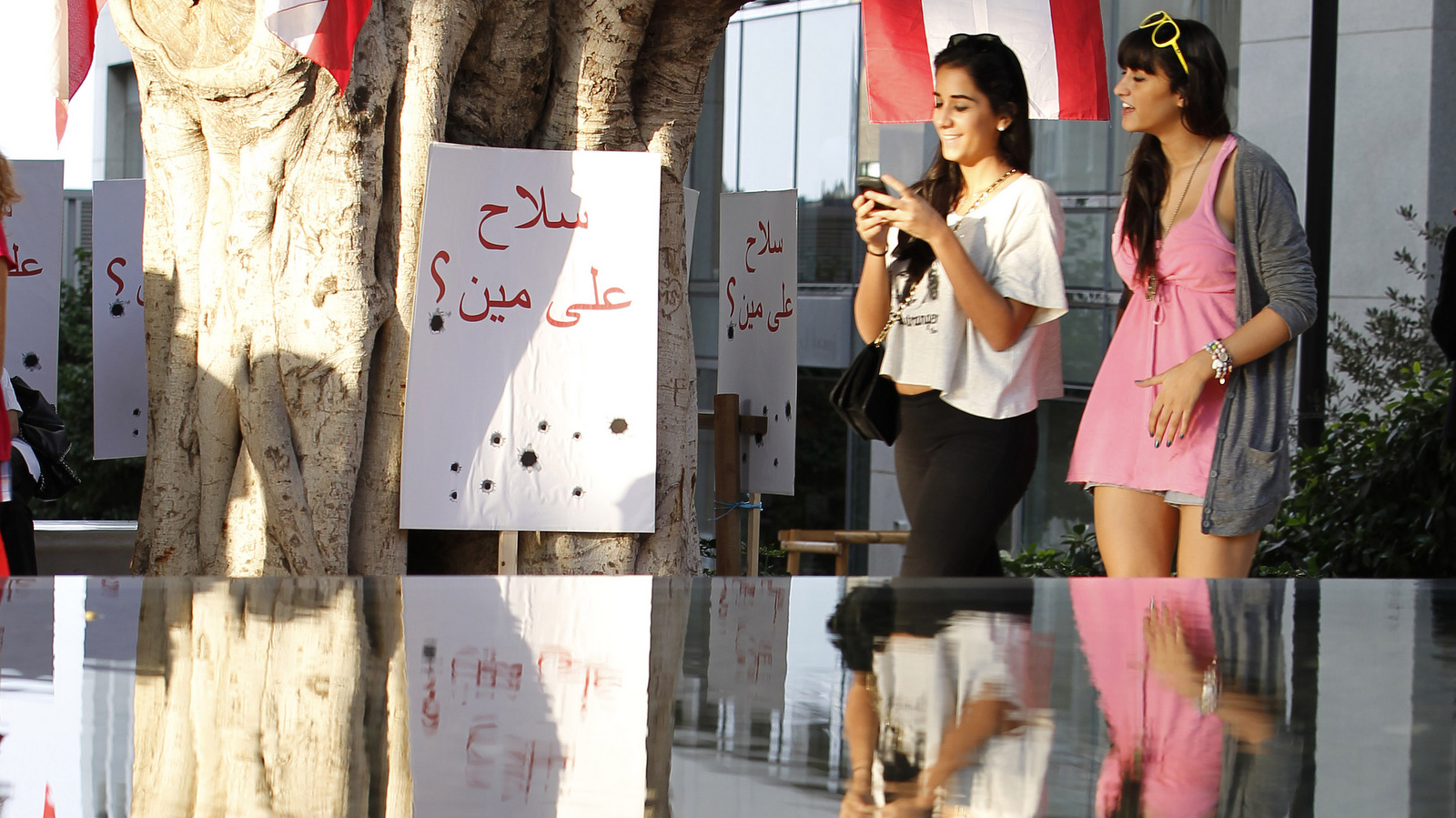 Lebanese activists stand near a banner that reads in Arabic:" towards whom is directed the weapon"?, during a sit-in organized by various groups as they demand the government to take action against the widespread of uncontrolled weapons in Beirut, Lebanon, Wednesday, Sept. 15, 2010. A Western-backed alliance in Lebanon's government, the March 14 coalition, named after a demonstration to demand Syria leave Lebanon, accused the militant group Hezbollah and its allies on Wednesday of trying to take the country back to the days before the 2005 "Cedar Revolution." (AP/Hussein Malla)