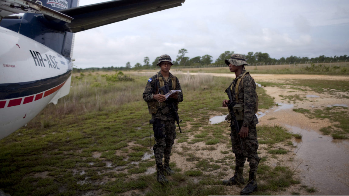 Honduran soldiers stand next to a plane in Brus Laguna , Honduras. A joint Honduran-U.S DEA drug raid targeted civilians in the remote jungle area, killing four riverboat passengers and injuring four others. (AP/Rodrigo Abd)