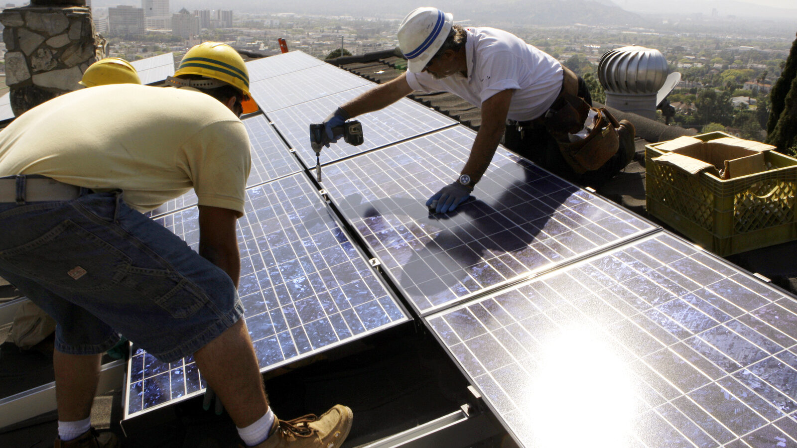 Workers from California Green Design install solar electrical panels on the roof of a home in Glendale, Calif. California. (AP/Reed Saxon, File)