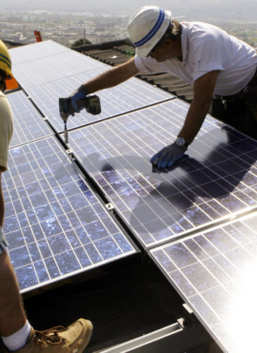 Workers from California Green Design install solar electrical panels on the roof of a home in Glendale, Calif. California. (AP/Reed Saxon, File)