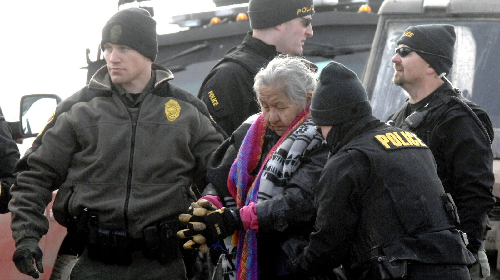 An elderly woman is escorted to a transport van after being arrested by law enforcement at the Oceti Sakowin camp as part of the final sweep of the Dakota Access pipeline protesters in Morton County, Feb. 23, 2017, near Cannon Ball, N.D. (Mike McCleary/The Bismarck Tribune)