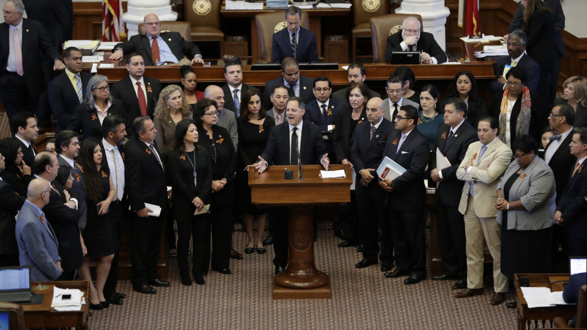 Texas Rep. Rafael Anchia, D-Dallas, at podium, is surrounded by fellow lawmakers as he speaks against an anti-"sanctuary cities" bill that has already cleared the Texas Senate and seeks to jail sheriffs and other officials who refuse to help enforce federal immigration law, Wednesday, April 26, 2017, in Austin, Texas. (AP/Eric Gay)