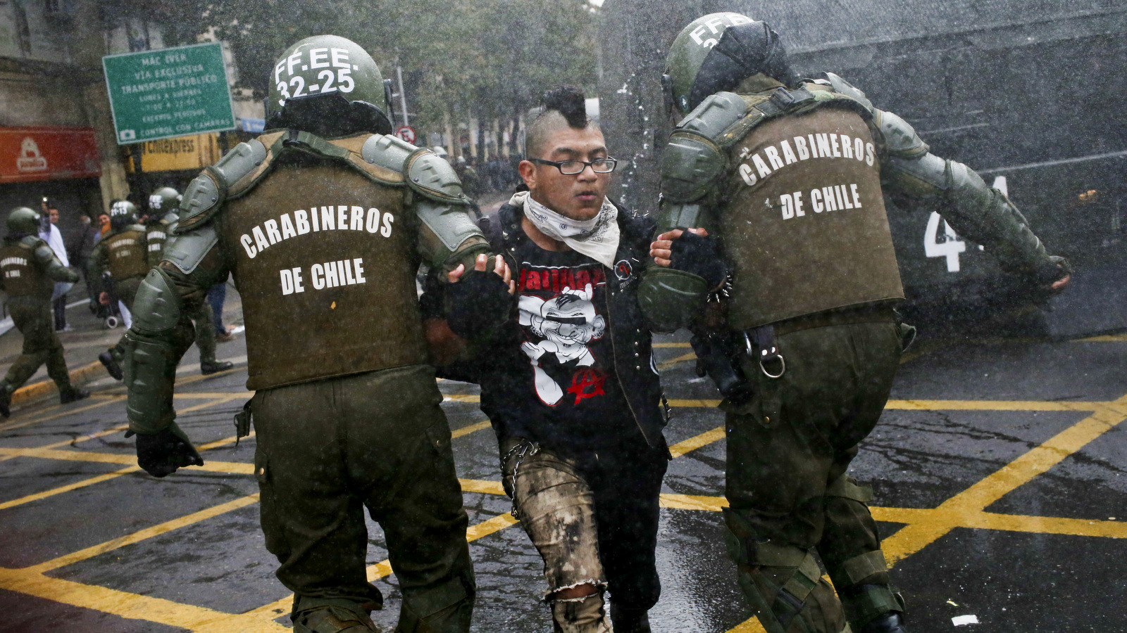 A student is detained by police after throwing an object at them during a protest march demanding the government overhaul the education funding system that would include canceling their student loan debt, in Santiago, Chile, May 9, 2017. Some students stay in debt for up to 20 years after completing their studies. (AP/Esteban Felix)