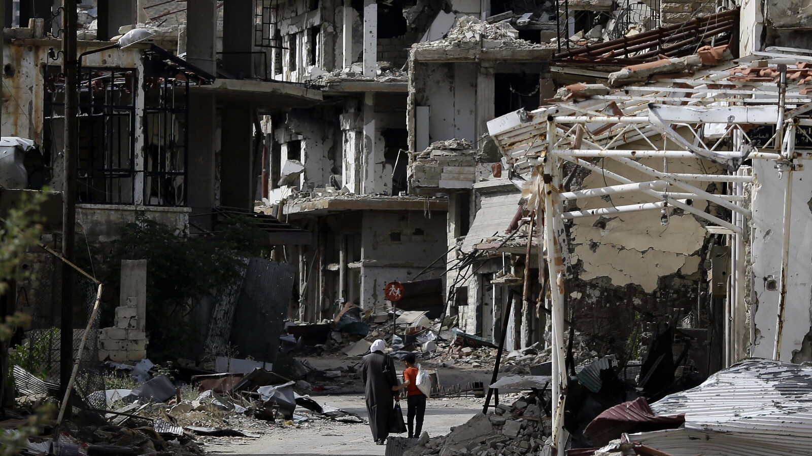 Residents walk through damaged streets at the mountain resort town of Zabadani in the Damascus countryside, Syria, Thursday, May 18, 2017. A U.S. airstrike struck pro-Syrian government forces hitting a convoy in the desert near the border with Jordan, (AP/Hassan Ammar)