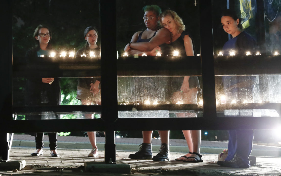 People gather for a candlelight vigil at a bus shelter at the University of Maryland in College Park, Md, May 21, 2017, where visiting student was fatally stabbed. (AP/Carolyn Kaster)