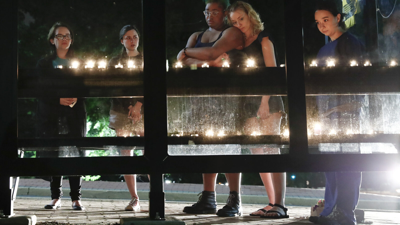 People gather for a candlelight vigil at a bus shelter at the University of Maryland in College Park, Md, May 21, 2017, where visiting student was fatally stabbed. (AP/Carolyn Kaster)