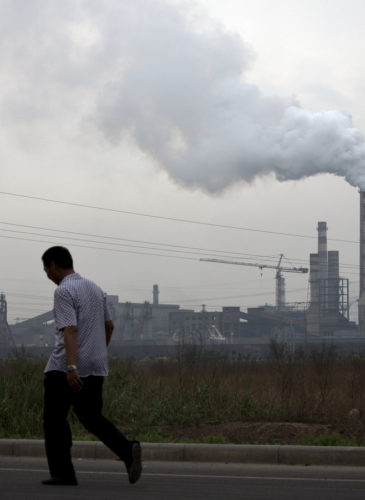 A man walks past a coal-powered steel plant in Tianjin, China. (AP/Andy Wong)