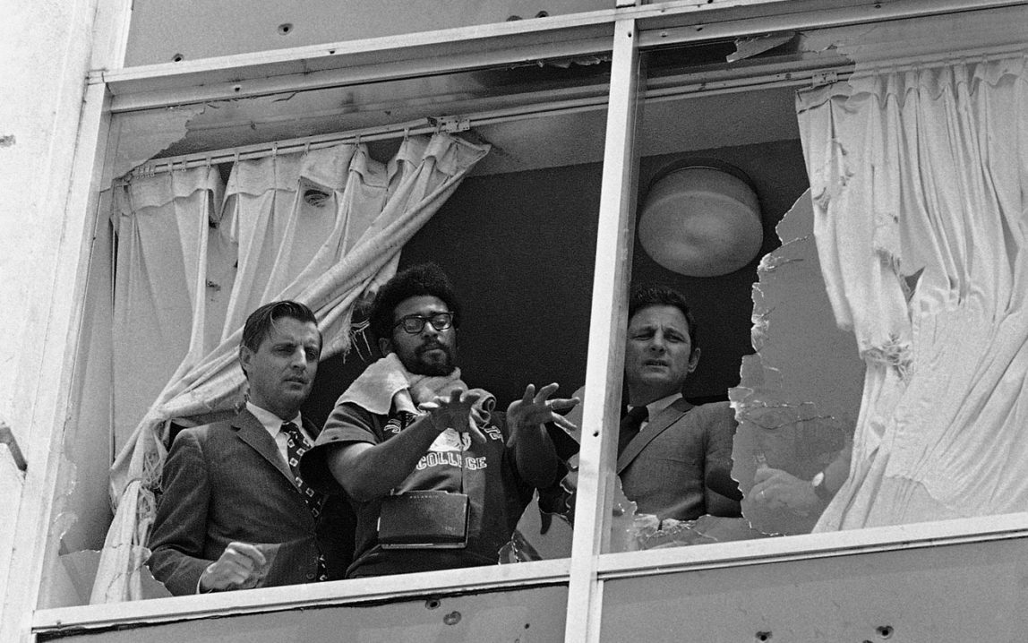 Sen. Walter Mondale, D-Minn.,left, and Sen. Birch Bayh, D-Ind., right, looking from shattered windows on to the area where two people were shot to death at what is now Jackson State University in Jackson, Miss. May 20, 1970. (AP Photo)