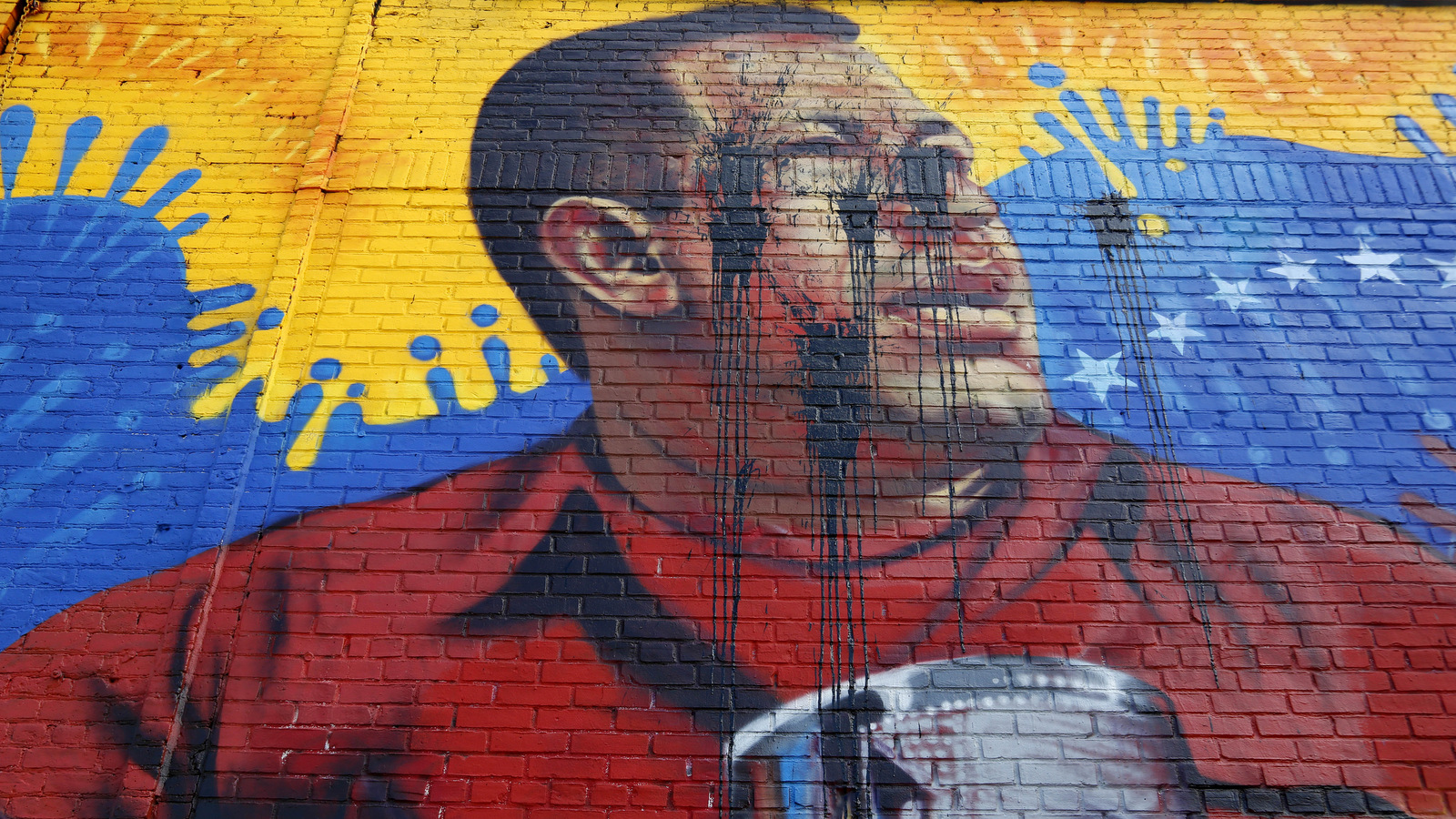 A mural featuring an image of former Venezuelan President Hugo Chavez was defaced in the Bronx borough of New York, Tuesday, May 9, 2017. (AP/Seth Wenig)