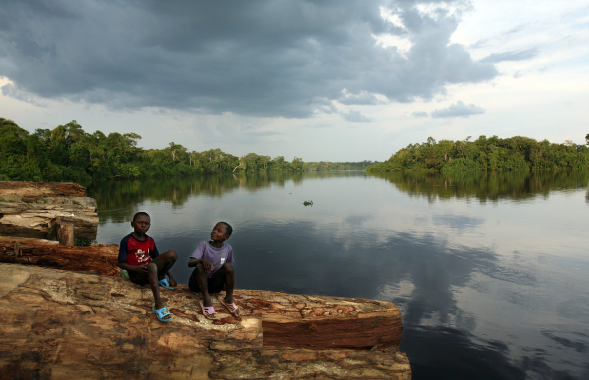 Children of a logger in the wait to be transported along the Lomami River, a tributary of the Congo River. Approximately 40 million people in the DRC depend on the rainforest for their basic needs, such as medicine, food or shelter. (Photo: Greenpeace/Jiro Ose)