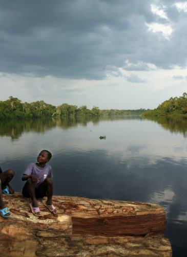 Children of a logger in the wait to be transported along the Lomami River, a tributary of the Congo River. Approximately 40 million people in the DRC depend on the rainforest for their basic needs, such as medicine, food or shelter. (Photo: Greenpeace/Jiro Ose)