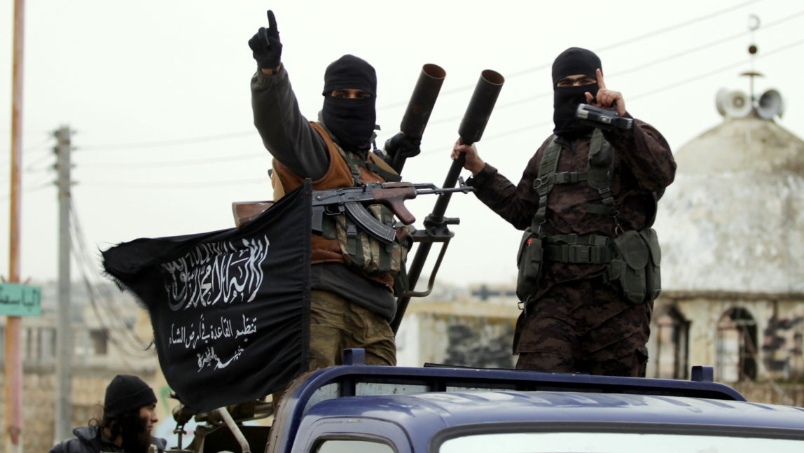 Members of al-Nusra Front gesture as they drive in a convoy touring villages in the southern countryside of Syria's Idlib province, Decembe, 2014. (Photo: Khalil Ashawi/Reuters)