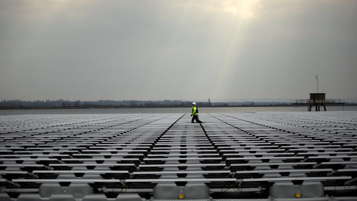 Contractors work on Europe's biggest floating solar panel array on the Queen Elizabeth II Reservoir near Walton-on-Thames in south west London, Monday, March 21, 2016. (AP/Matt Dunham)