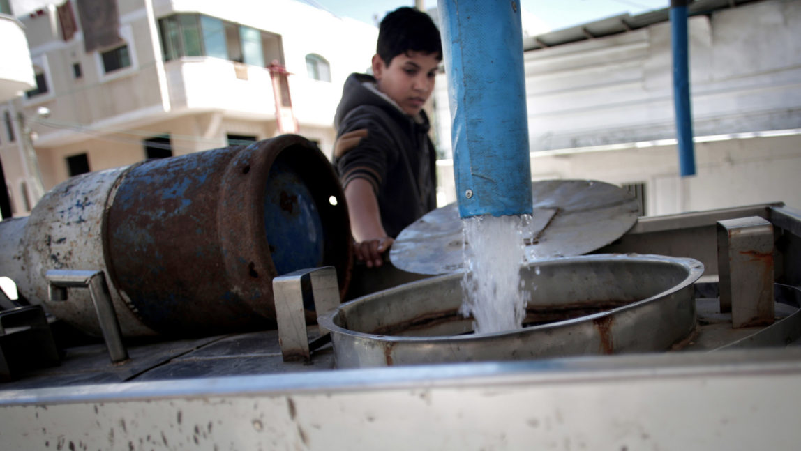 A Palestinian man fills tankers with drinking water for sale at a drinking water station in Gaza City. Poor sewage treatment is a feature of life in Gaza, a result of infrastructure damaged during wars with Israel and a chronic shortage of electricity to run wastewater plants. (AP/Khalil Hamra)