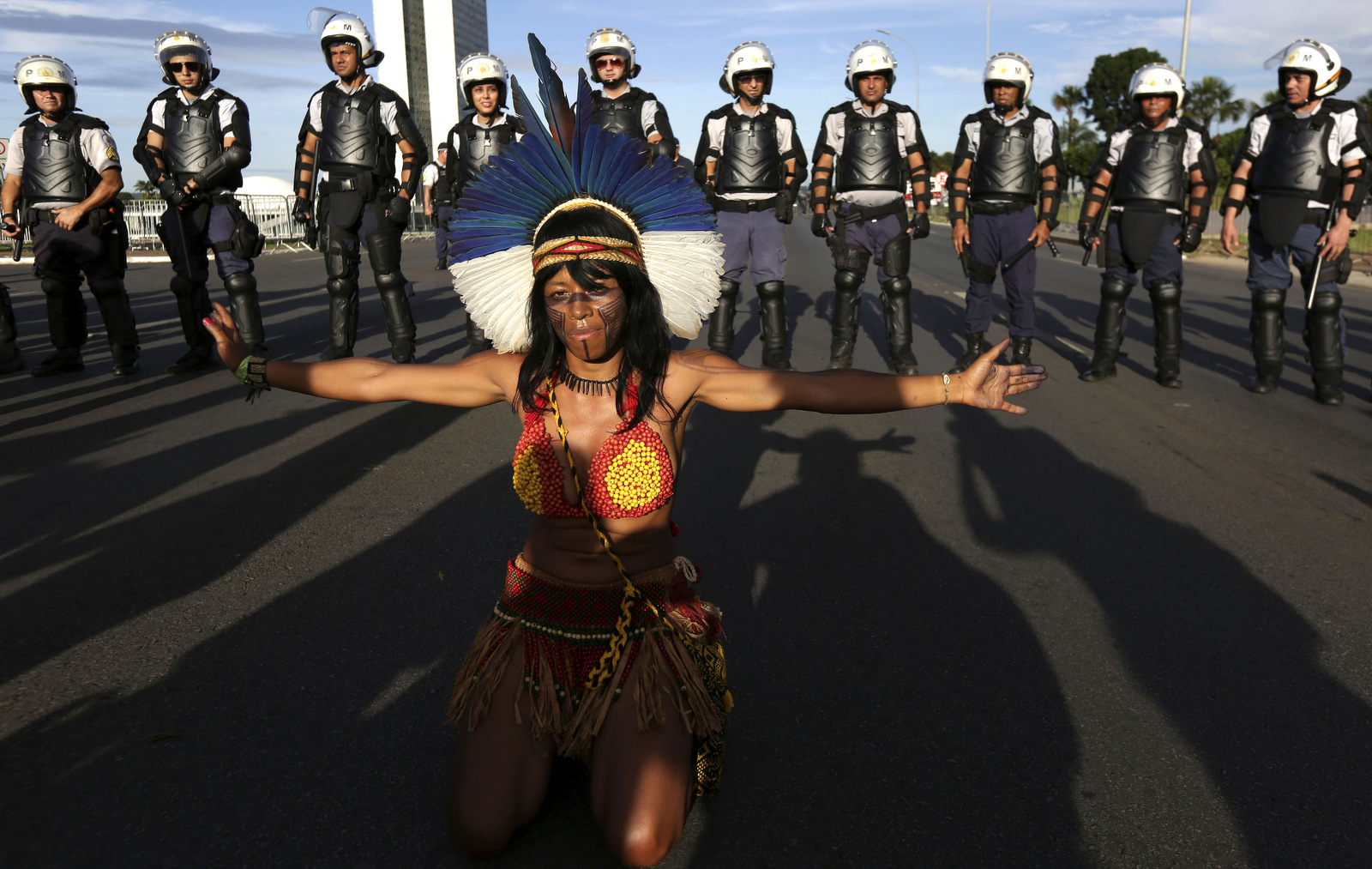 A Pataxo indigenous woman performs in front of police during the Indigenous Peoples Ritual March outside the National Congress in Brasilia, Brazil, April 27, 2017. (AP/Eraldo Peres)