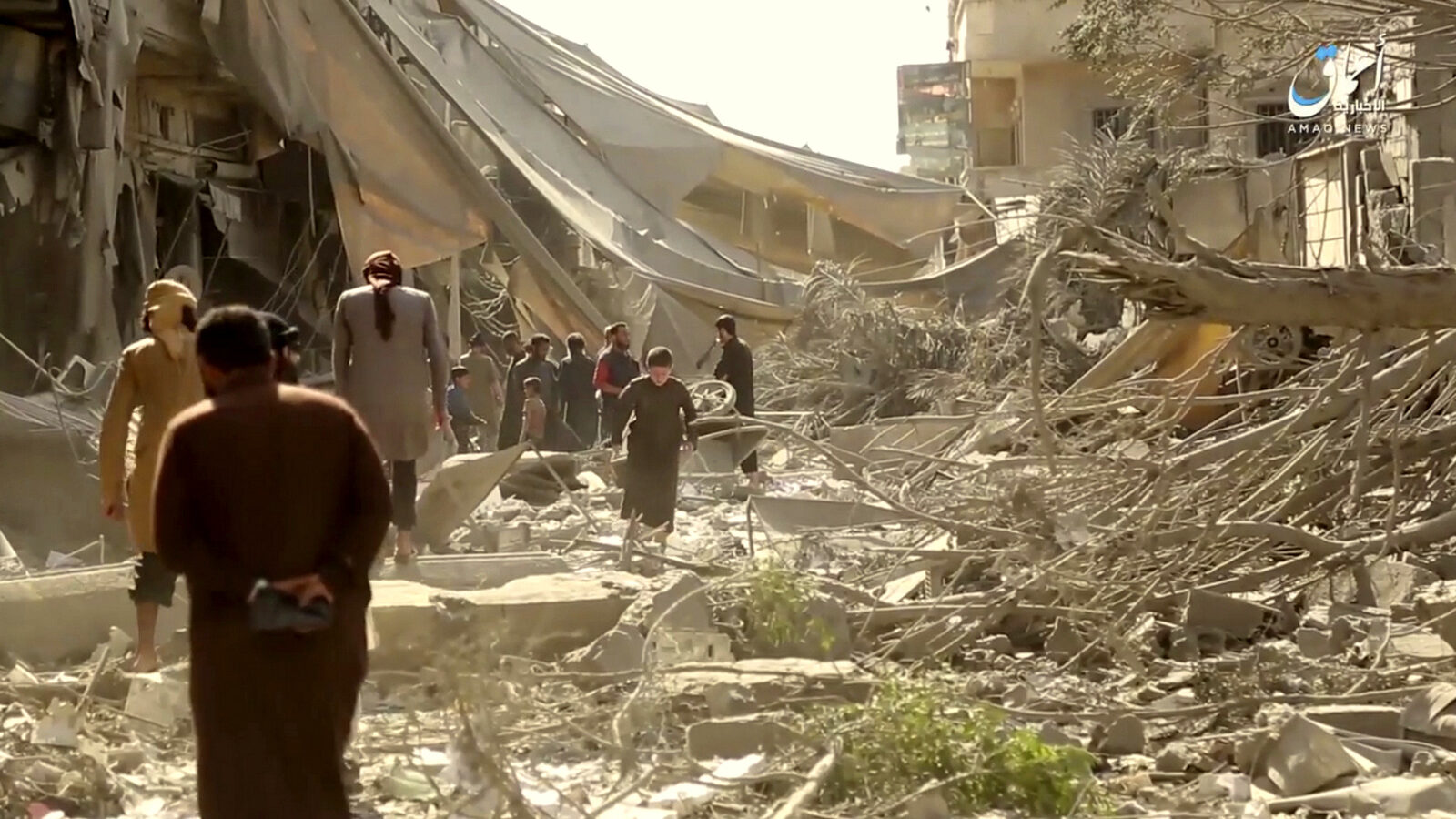 People inspect damage from US coalition airstrikes and artillery shelling in the northern Syrian city of Raqqa, Syria, May 29, 2017. (Aamaq via AP)