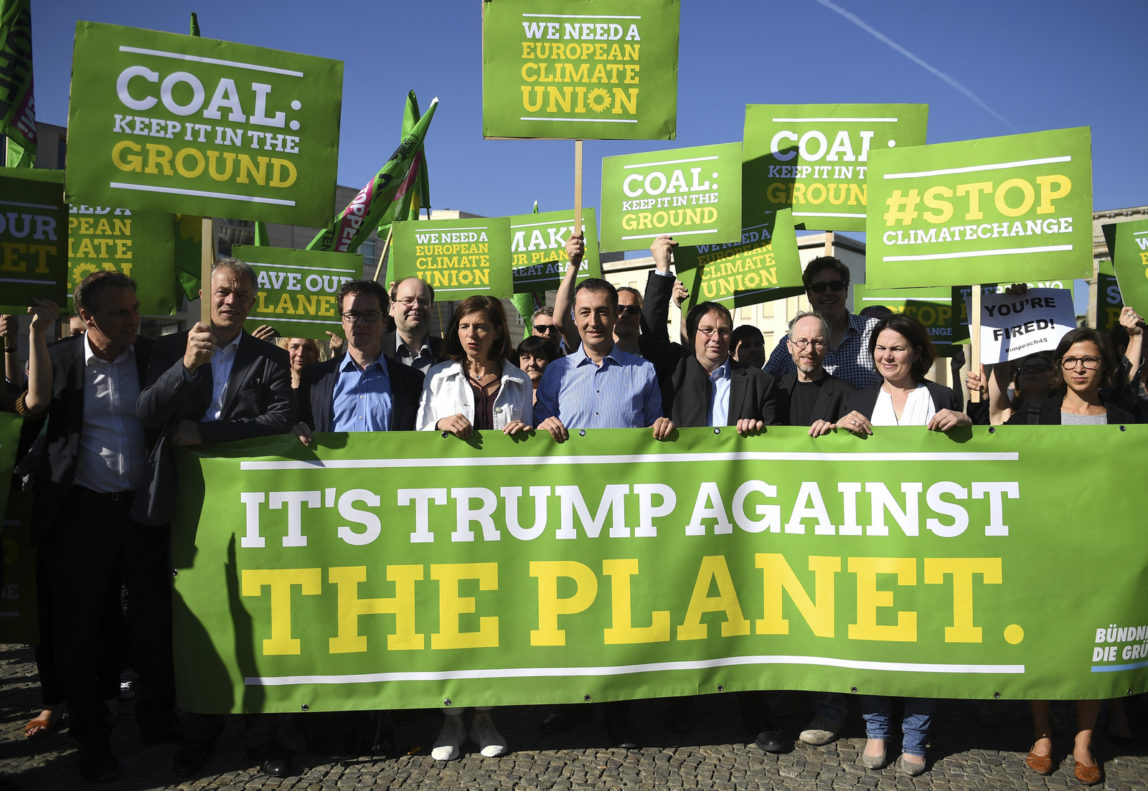 Germans protest against US President Trump's decision to exit the Paris climate agreement in front the the US embassy in Berlin, Germany, Friday, June 2, 2017. (Britta Pedersen/dpa via AP)