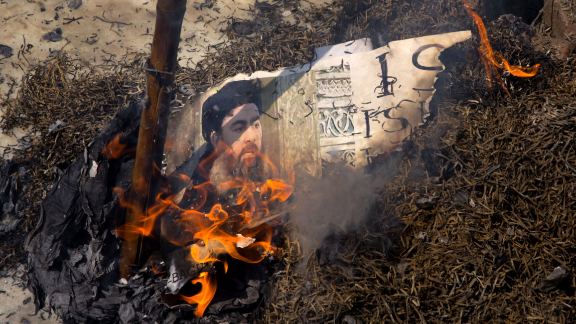 Shia Muslims burn an effigy of the leader of the ISIS, Abu Bakr al-Baghdadi during a protest in New Delhi, India, Friday, June 9, 2017. The protest was sparked by the Wednesday's attacks on Iran's parliament and the tomb of its revolutionary leader that killed over a dozen. The banner read: ISIS equals Satan. (AP/Manish Swarup)