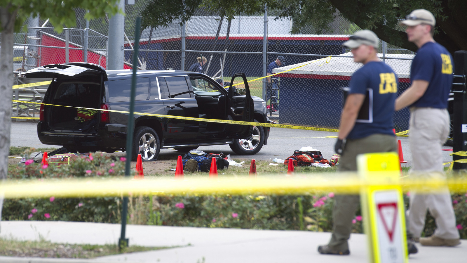 An SUV, with a bullet hole in the windshield and a flat tire, sits in the parking lot at the scene of a multiple shooting in Alexandria, Va.,, June 14, 2017, during a congressional baseball practice. (AP/Cliff Owen)