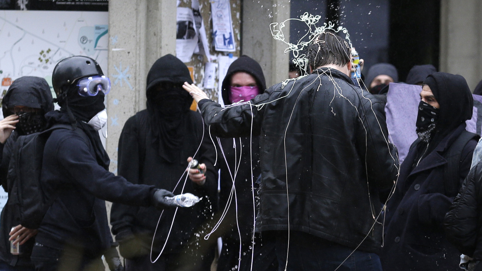 Counter-protesters spray a man who was filming them with a mobile phone with silly string and water, Thursday, June 15, 2017, during a protest by the conservative group Patriot Prayer at The Evergreen State College in Olympia, Wash. (AP/Ted S. Warren)