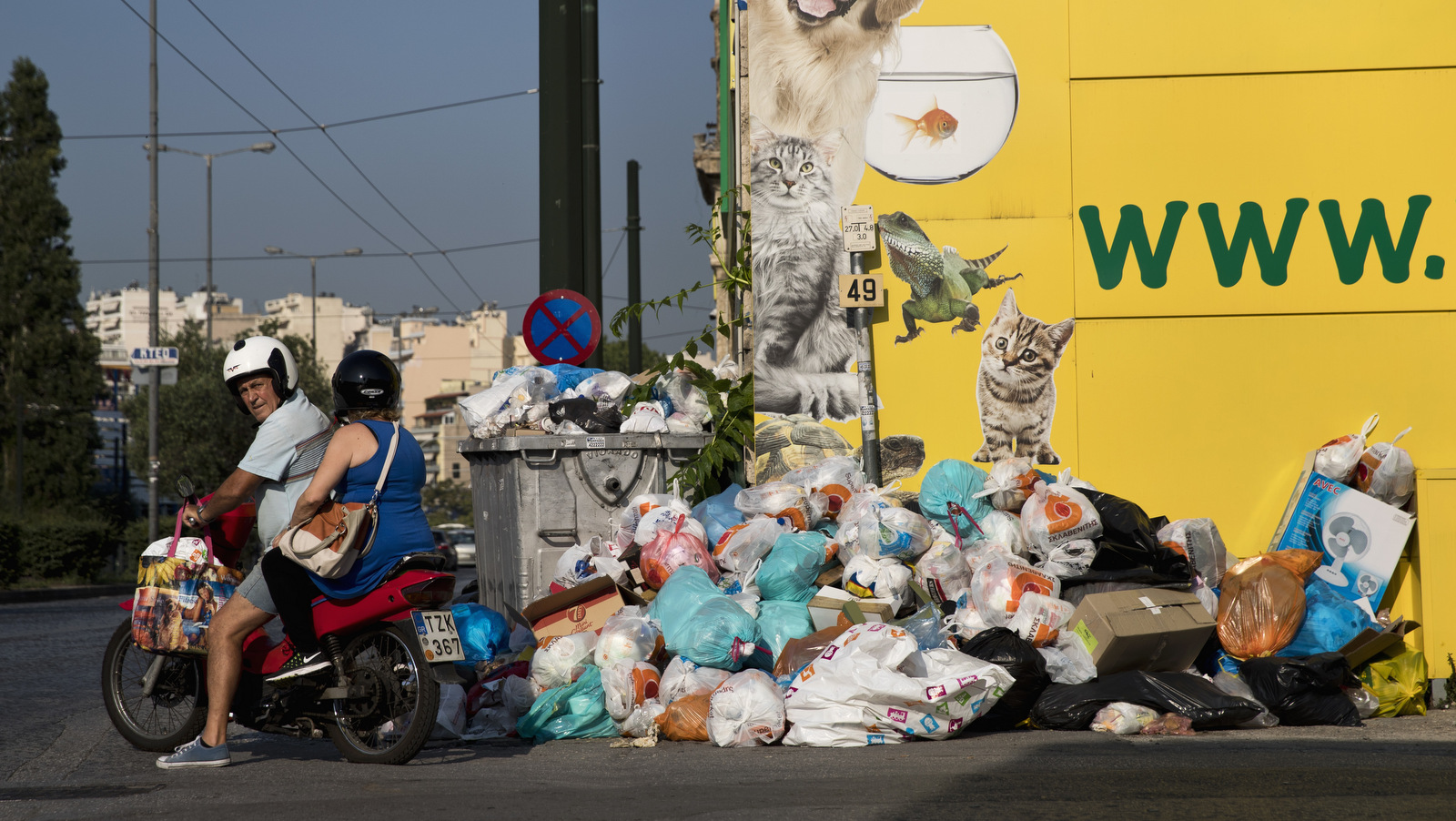 A motorcyclist looks on as he drives next to a pile of garbage in Piraeus, near Athens, on Monday, June 26, 2017. Municipality workers have been on strike for almost a week , hindering trash collection across the country. (AP/Petros Giannakouris)