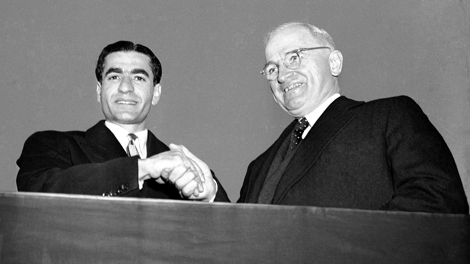 The Shah of Iran Reza Pahlavi, left, and President Harry Truman pose on the speakers rostrum during welcoming ceremonies at National Airport on Nov. 16, 1949 in Washington. (AP Photo)
