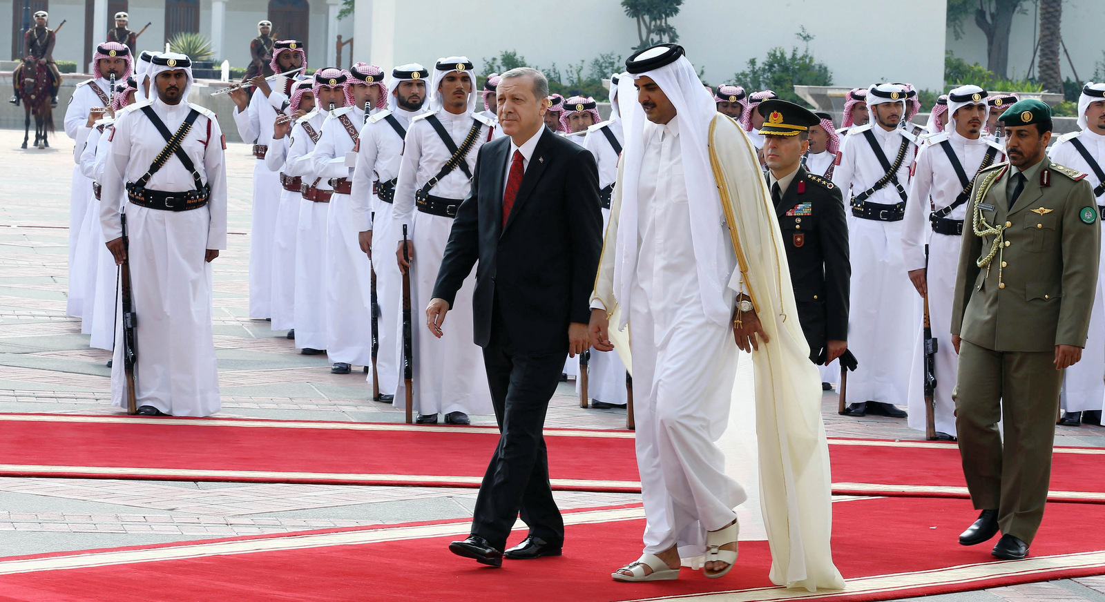 Turkey's President Recep Tayyip Erdogan, left, and Qatar's Emir Tamim bin Hamad Al Thani inspect a military honour guard during a ceremony in Doha, Qatar, Dec. 2, 2015. Turkey approved a bill allowing expedited troop deployment to its base in Qatar. (AP/Yasin Bulbul,)