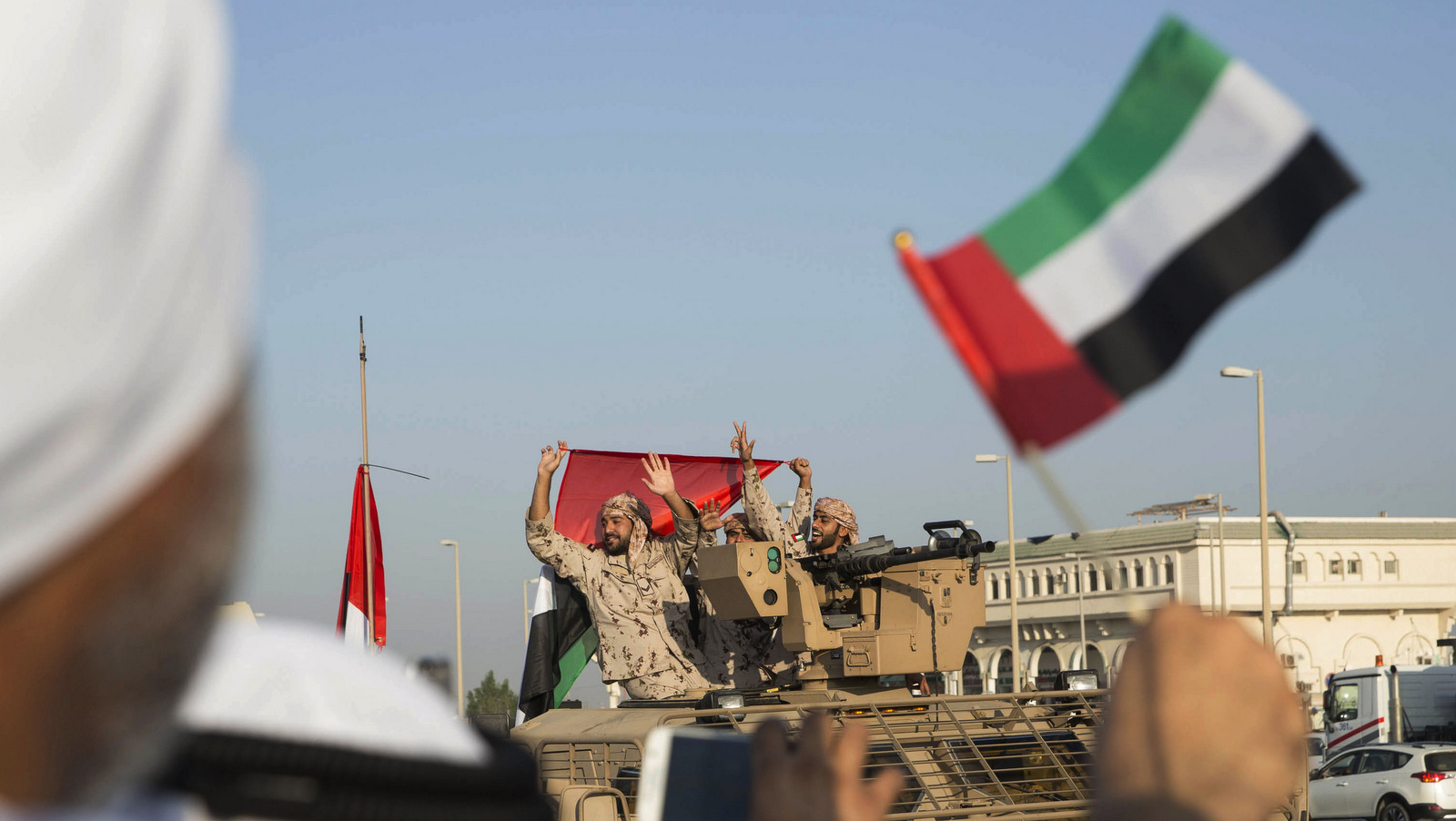 Emiratis wave the national flag as a convoy of UAE military personnel return from fighting in Yemen, Nov. 7, 2015. (Ryan Carter-Crown Prince Court/AP)