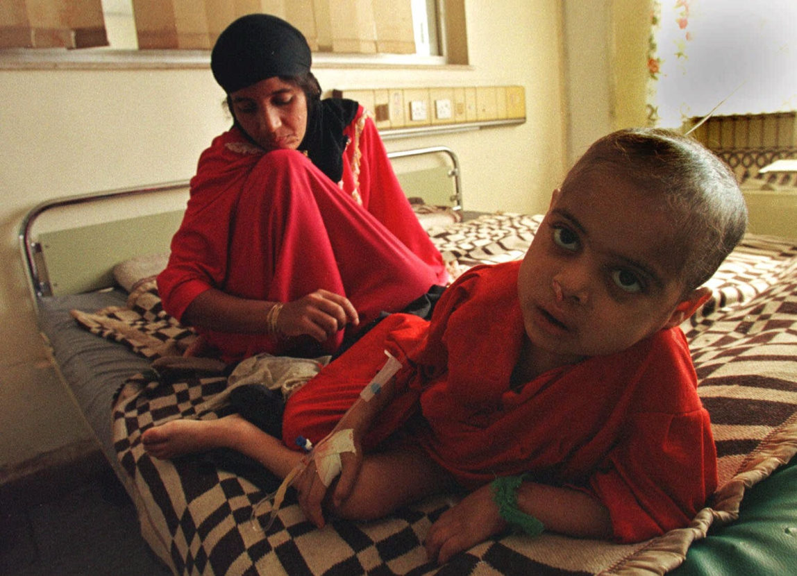 Suffering from leukemia, 5 year-old Sahira lies in her bed as her mother weeps at the Saddam Children's Hospital in Baghdad Tuesday, Jan. 12, 1999. (AP/Murad Sezer)