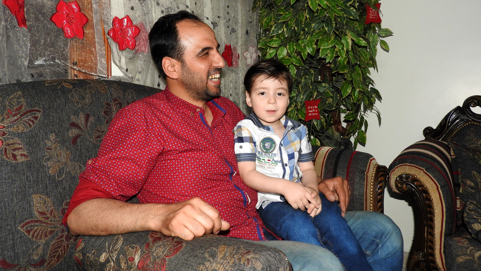 Omran Daqneesh, dubbed Aleppo Boy by the media, and his father Mohammed, in their Aleppo home, June 6, 2017. (Photo: Eva Bartlett,MintPress News)