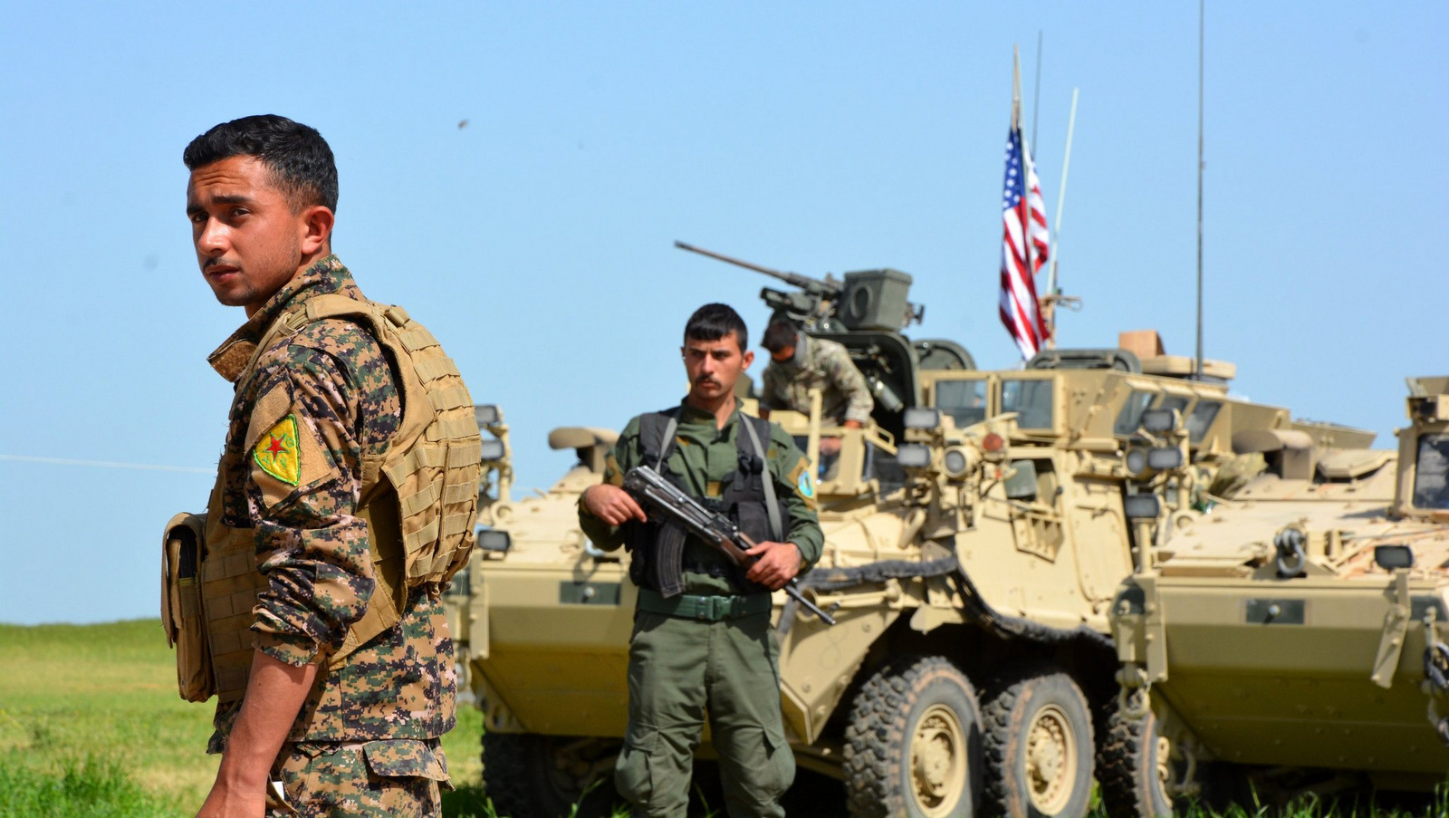 Kurdish fighters from the People’s Protection Units, (Y.P.G), stand guard next to American armored vehicles at the Syria-Turkey border, Apri, 2017. (Youssef Rabie Youssef/EPA)