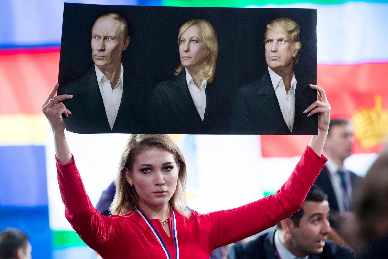 A journalist holds a poster with portraits of President Vladimir Putin, Marine Le Pen and Donald Trump prior to Putin’s annual news conference in Moscow. Dec, 2016. (Photo: Pavel Golovkin/AP)