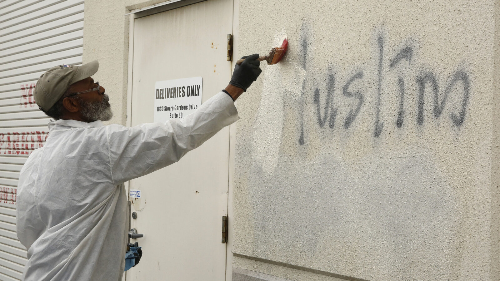 Willie Lawson paints over racist graffiti painted on the side of a mosque in Roseville, Calif. (AP/Rich Pedroncelli)