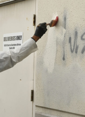 Willie Lawson paints over racist graffiti painted on the side of a mosque in Roseville, Calif. (AP/Rich Pedroncelli)