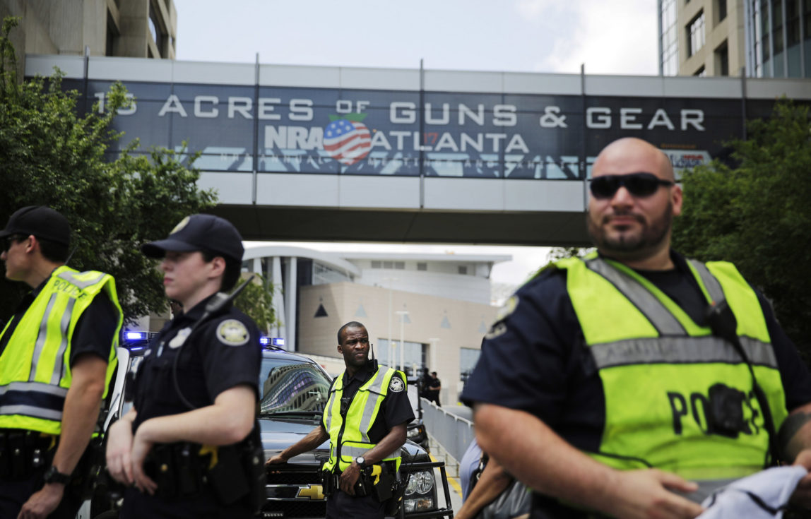 Police stand watch during a protest across the street from the National Rifle Association's annual convention where Donald Trump was scheduled to speak in Atlanta, April 28, 2017. (AP/David Goldman)