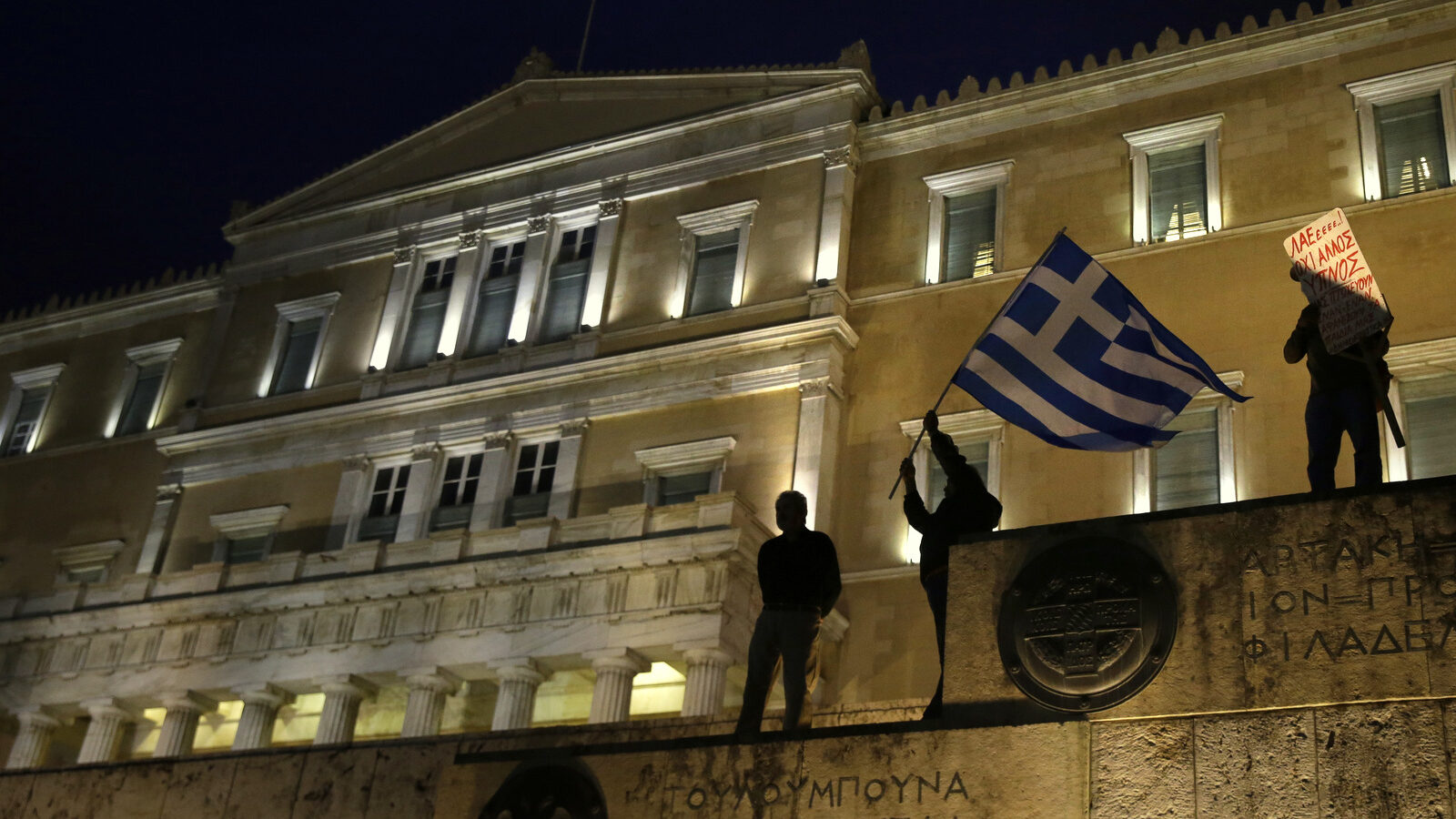 A man waves a Greek flag in front of the Greek Parliament during a rally against new austerity measures in Athens, May 18, 2017. (AP/Yorgos Karahalis)