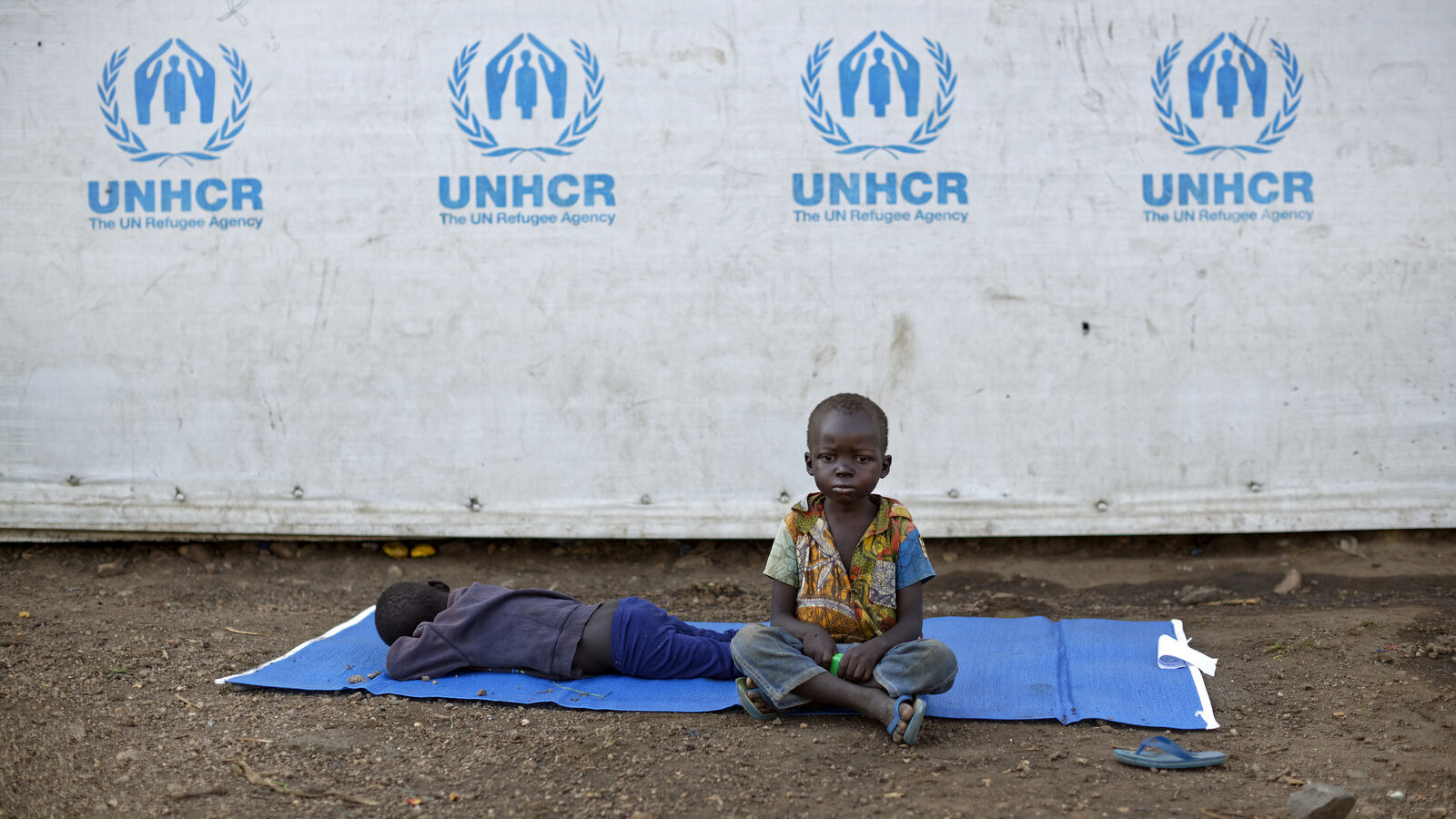A South Sudanese refugee sits on a mat outside a communal tent with his brother at the Imvepi reception center, where newly arrived refugees are processed in northern Uganda Friday, June 9, 2017. (AP/Ben Curtis)