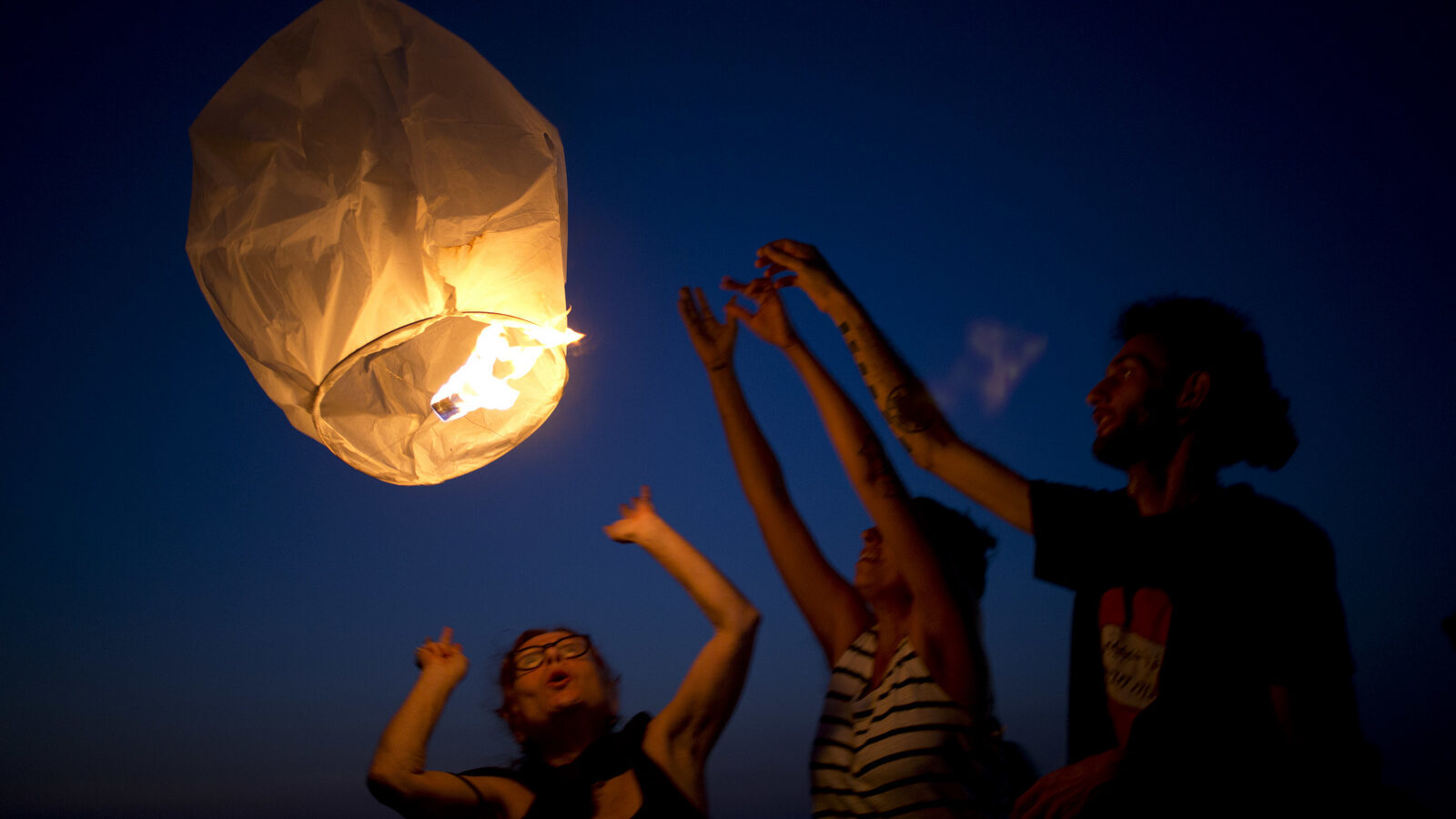 Activists release paper lanterns in solidarity with Palestinians from Gaza, at the Ashkelon beachafter Israel cut back its already limited electricity shipments to the Gaza Strip in a step that is expected to worsen the power crunch plaguing the Hamas-controlled seaside territory, June 19, 2017. (AP/Ariel Schalit)