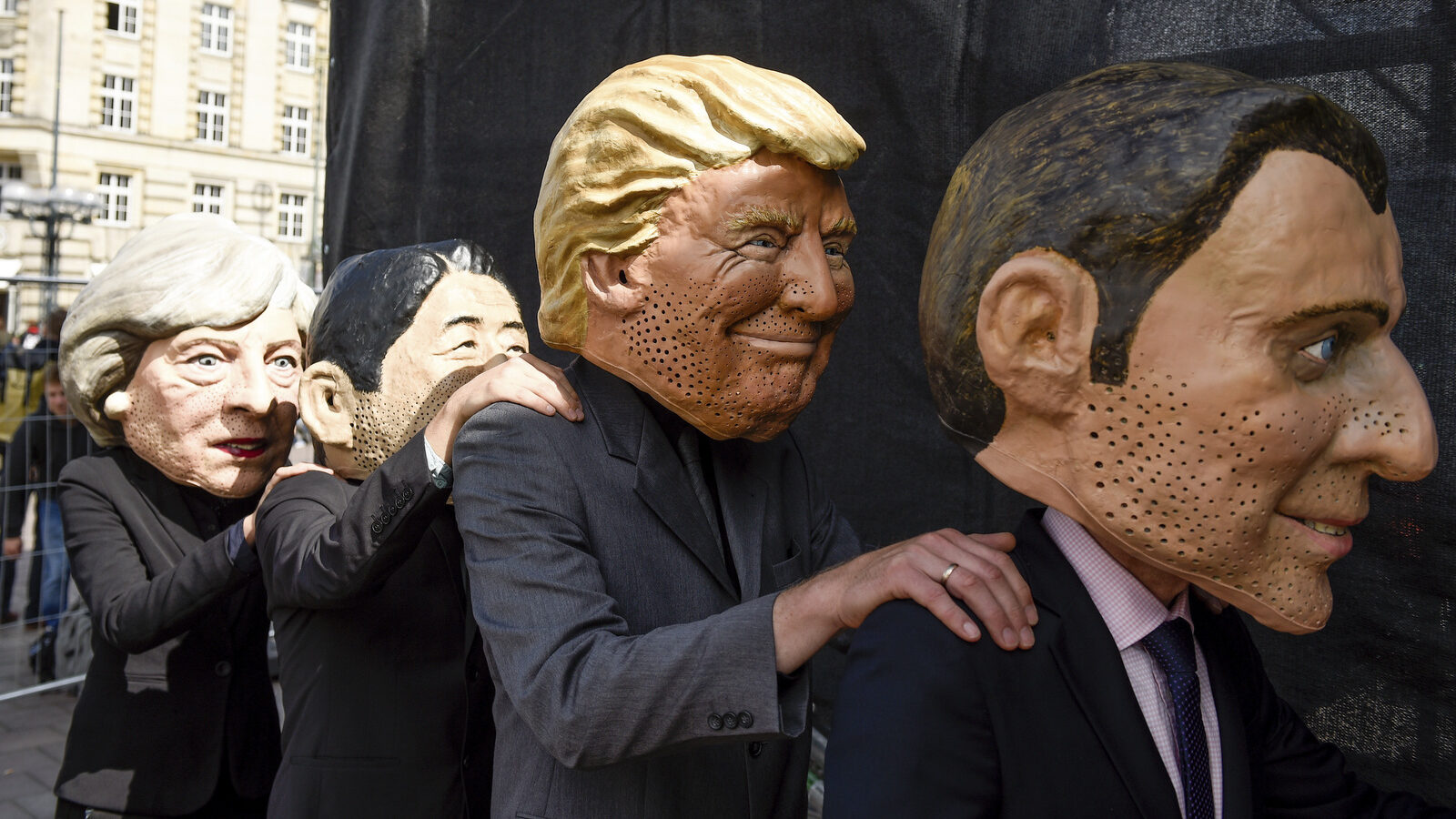 Demonstrators against the G20 Summit stand on stage wearing masks depicting from left : British Prime Minister Theresa May, Japan's Prime Minister Shinzo Abe, US President Donald Trump and French President Emmanuel Macron, in Hamburg, Germany, July 2, 2017. (Axel Heimken/AP)
