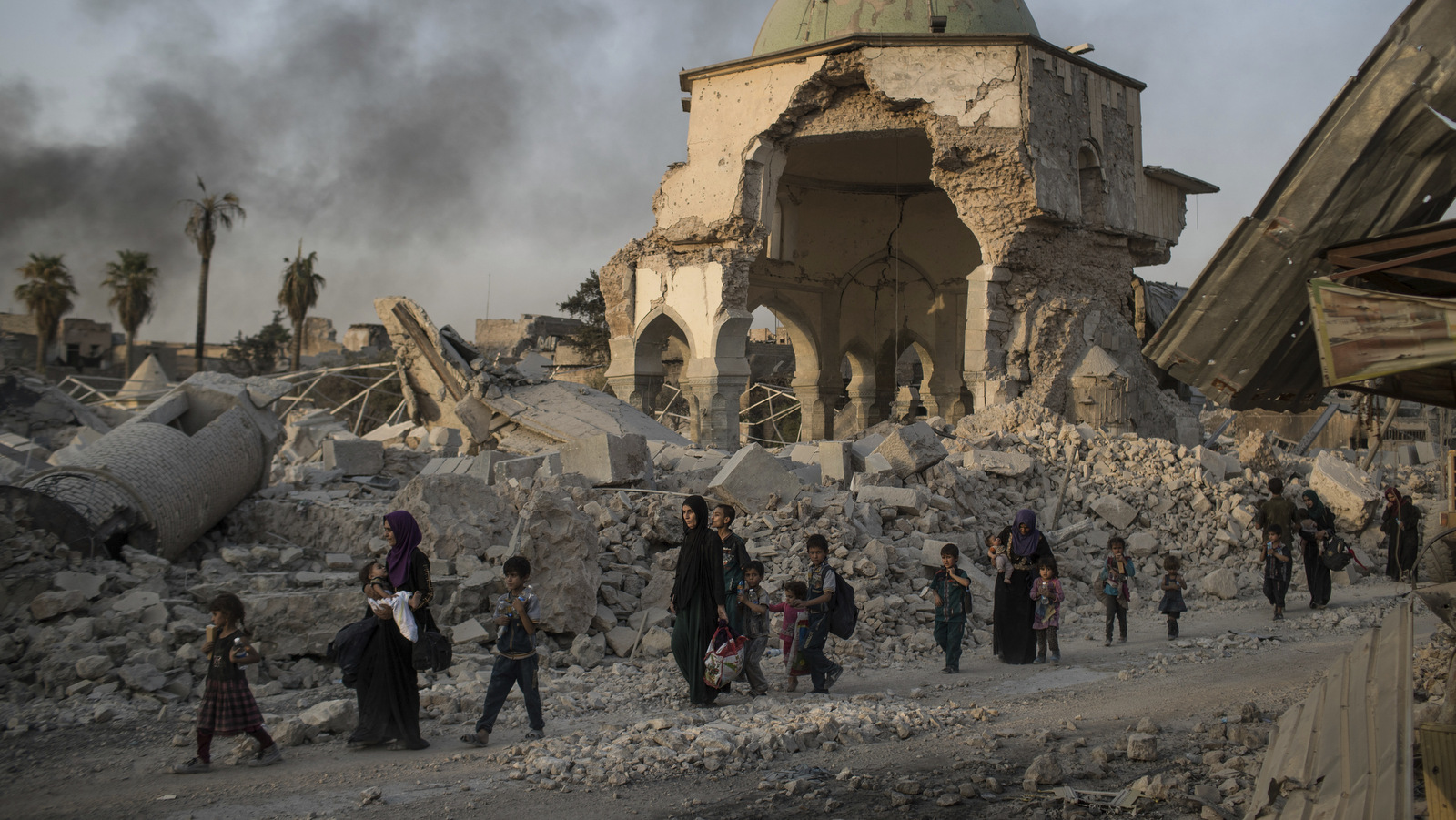 Fleeing Iraqi civilians walk past the heavily damaged al-Nuri mosque as Iraqi forces continue their advance against ISIS militants in the Old City of Mosul, Iraq, July 4, 2017 (AP/Felipe Dana)