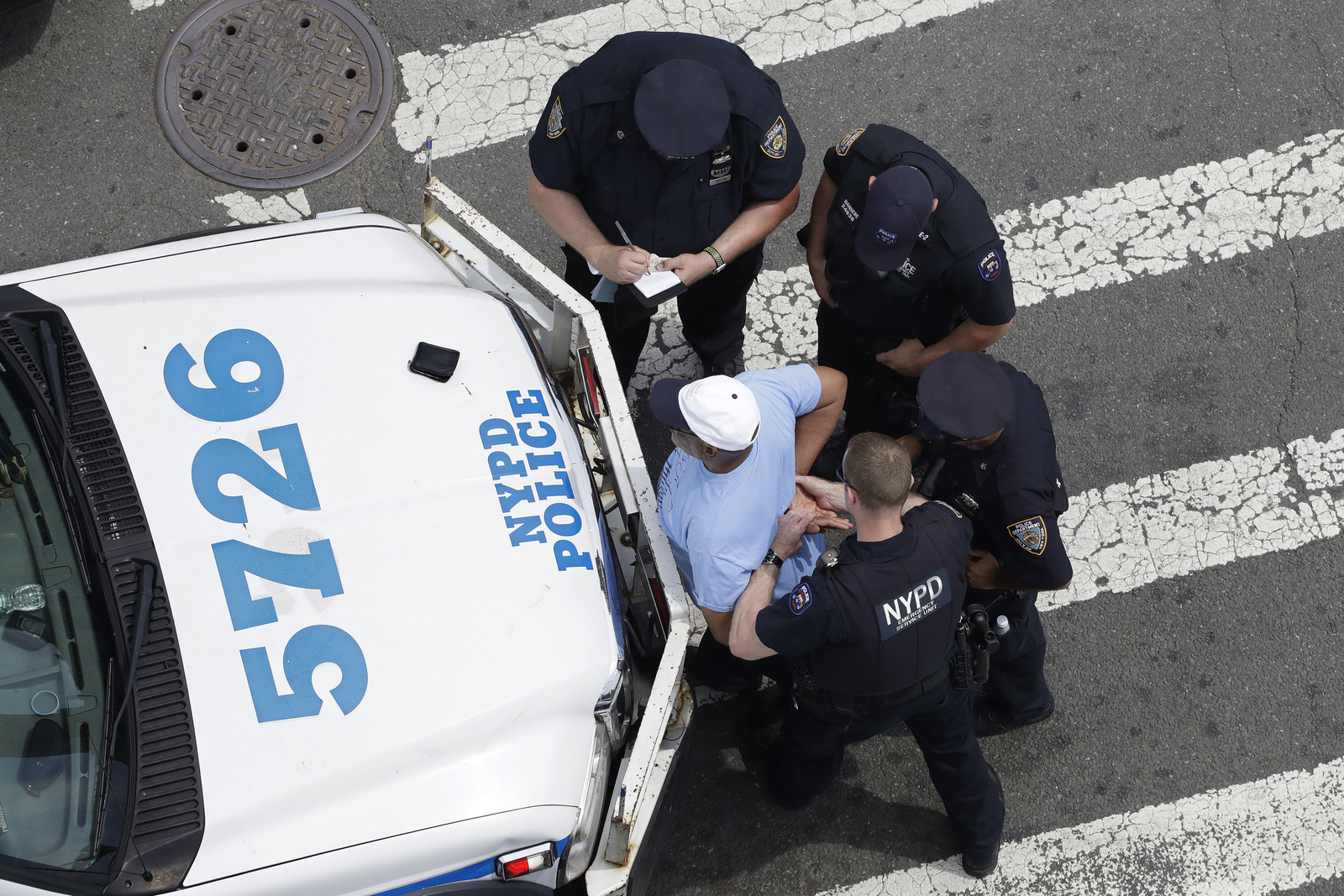 New York City police officers detain and question a man, Tuesday, July 11, 2017, in the Bronx borough of New York. The man was released. (AP/Mark Lennihan)