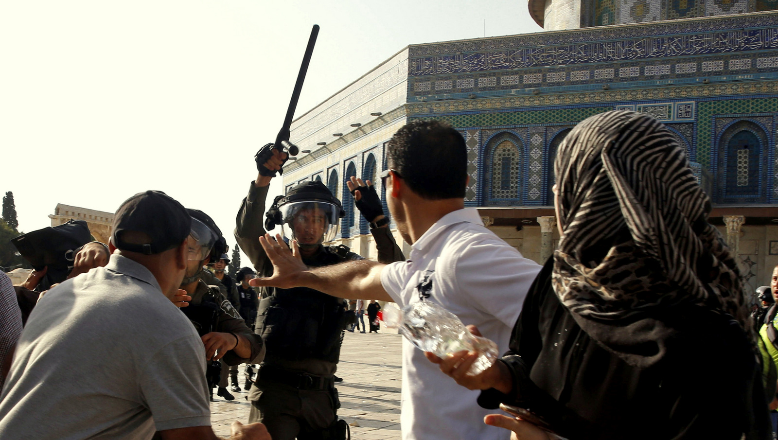 An Israeli police officer raises his baton on Palestinians worshipers near the Al Aqsa Mosque in Jerusalem’s Old City, July 27, 2017. Mahmoud Illean | AP