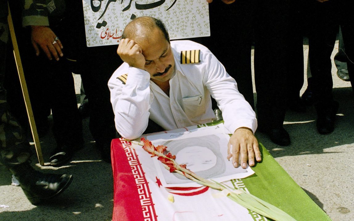 An Iran Air pilot mourns over the casket of his wife, Mina Motevaly, a crew member of Iran Air Flight 655 that was shot down over the Persian Gulf by the U.S. naval ship USS Vincennes, in Tehran, Iran, July 7, 1988. (AP/Mohammad Sayyad)