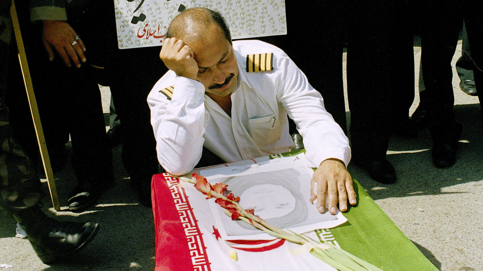 An Iran Air pilot mourns over the casket of his wife, Mina Motevaly, a crew member of Iran Air Flight 655 that was shot down over the Persian Gulf by the U.S. naval ship USS Vincennes, in Tehran, Iran, July 7, 1988. (AP/Mohammad Sayyad)