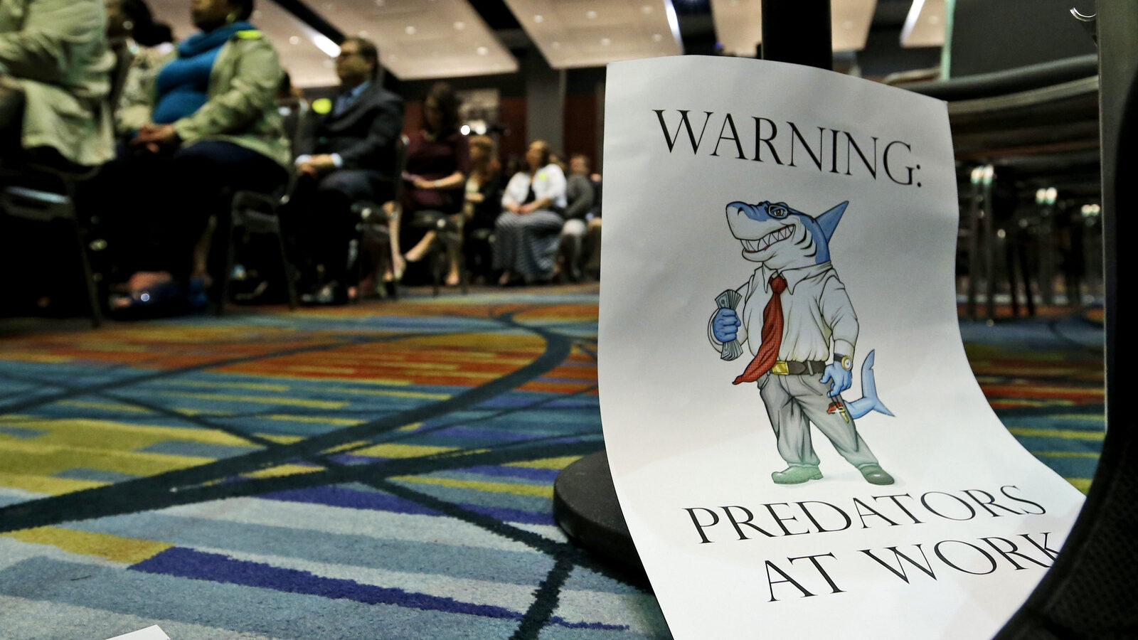 A sign leans against a chair during a speech by Consumer Financial Protection Bureau Director Richard Cordray, in Richmond, Va., March 26, 2015. (AP/Steve Helber)