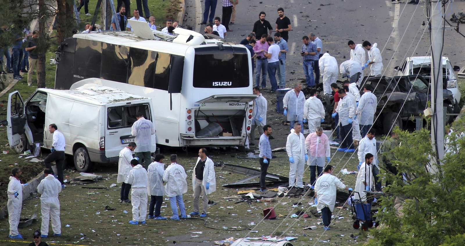 Oficiales de seguridad y forenses trabajan en el lugar de un coche bomba que golpeó un autobús en Diyarbakir, Turquía, el 10 de mayo de 2016. El ataque, llevado a cabo por el "Partido de los Trabajadores del Kurdistán, o PKK, tuvo como objetivo un autobús que transportaba agentes de policía matando al menos tres personas. (AP/Mahmut Bozarslán)