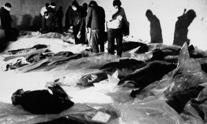 People looking for family members walk amid bodies of victims from Iran Air Flight 655 in a morgue in Bandar Abbas, July 4, 1988, a day after the USS Vincennes shot the passenger jet down over the Persian Gulf, killing 290 passengers and crew members, including 66 children. (AP/Mohammad Sayyad)