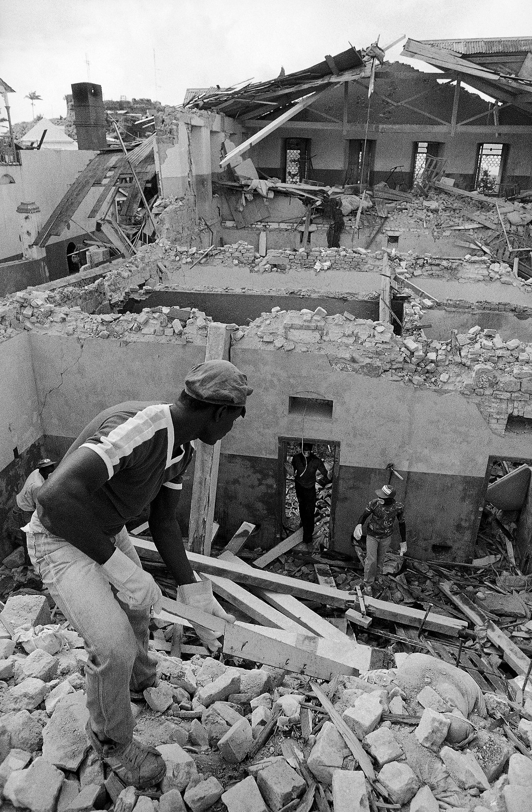 Workers sift through the bombed remains of the Richmond Hill Mental Hospital in St. George’s, Grenada on Friday, Nov. 4, 1983. The institution was bombed by U.S. forces during their invasion of Grenada. (AP/Pete Leabo)