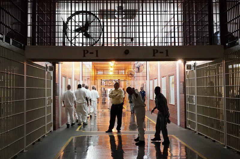 Prison staff and inmates move through the Darrington Unit's main hallway on July 12, 2017. (Jolie McCullough/The Texas Tribune)